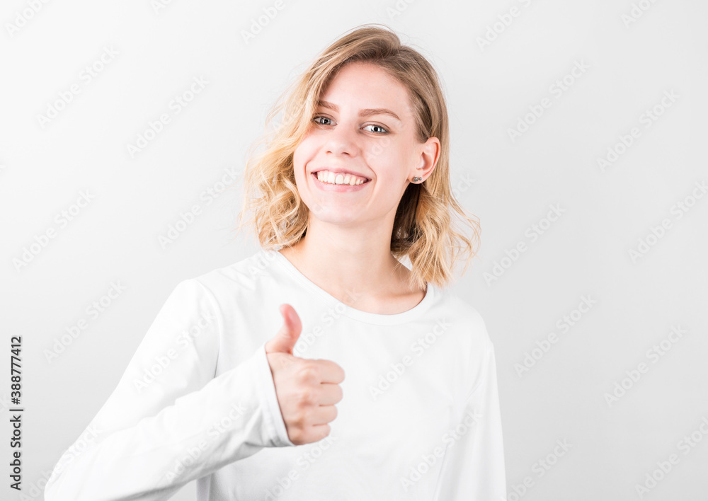 Smiling pretty young woman showing thumbs up isolated on white background Smiling pretty young woman showing thumbs up isolated on white background