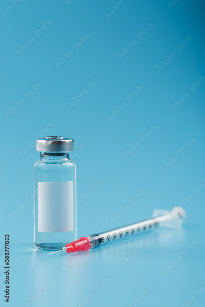 Syringe and ampoule with a vaccine against viruses and diseases on a blue background. Syringe and ampoule with a vaccine against viruses and diseases on a blue background.
