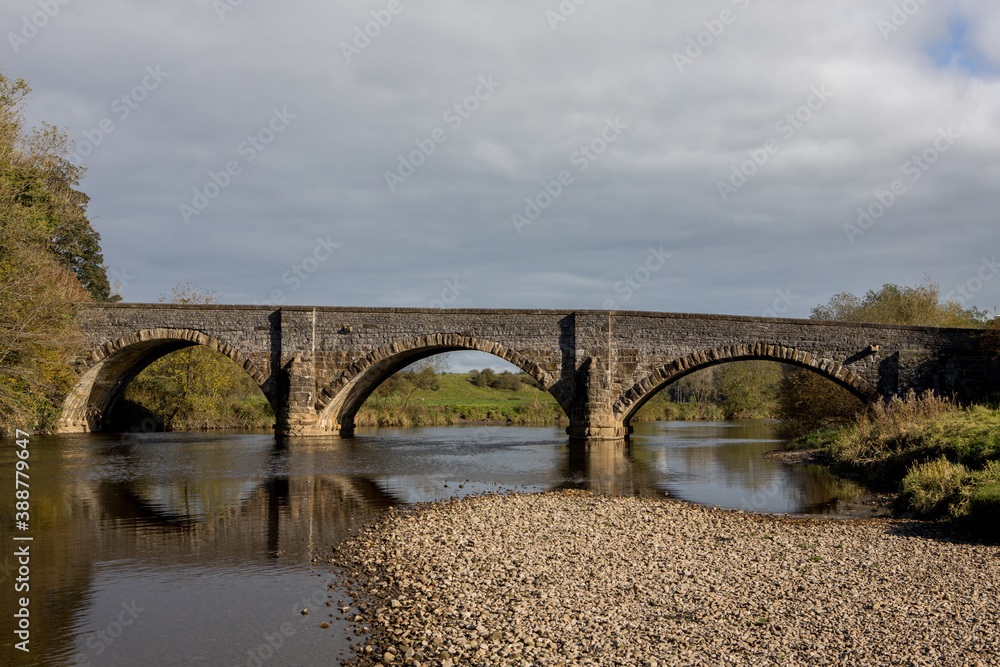 Fototapeta premium Brungerley bridge, Clitheroe. Large stone bridge over the river Ribble with reflections in the water