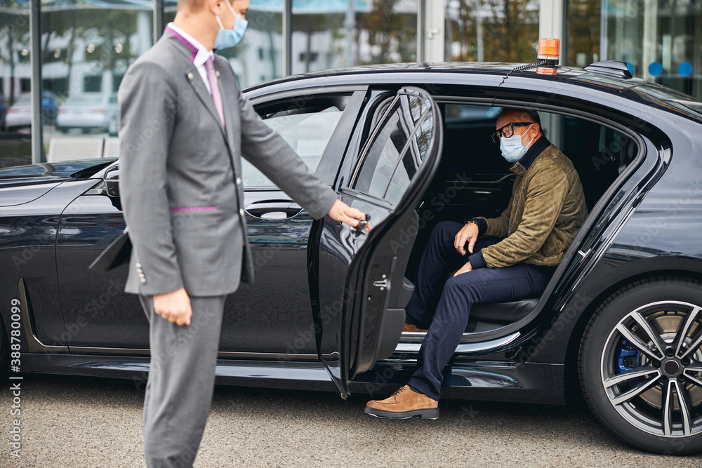 Man in eyeglasses getting out of the elite taxi Man in eyeglasses getting out of the elite taxi