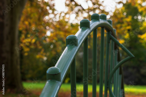 Detail of a green iron railing on a bridge in a park.