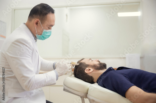 Hair mesotherapy or scalp prp: Platelet-rich plasma procedure. Beautician doctor makes injections in the man head for hair growth to prevent hair loss and baldness