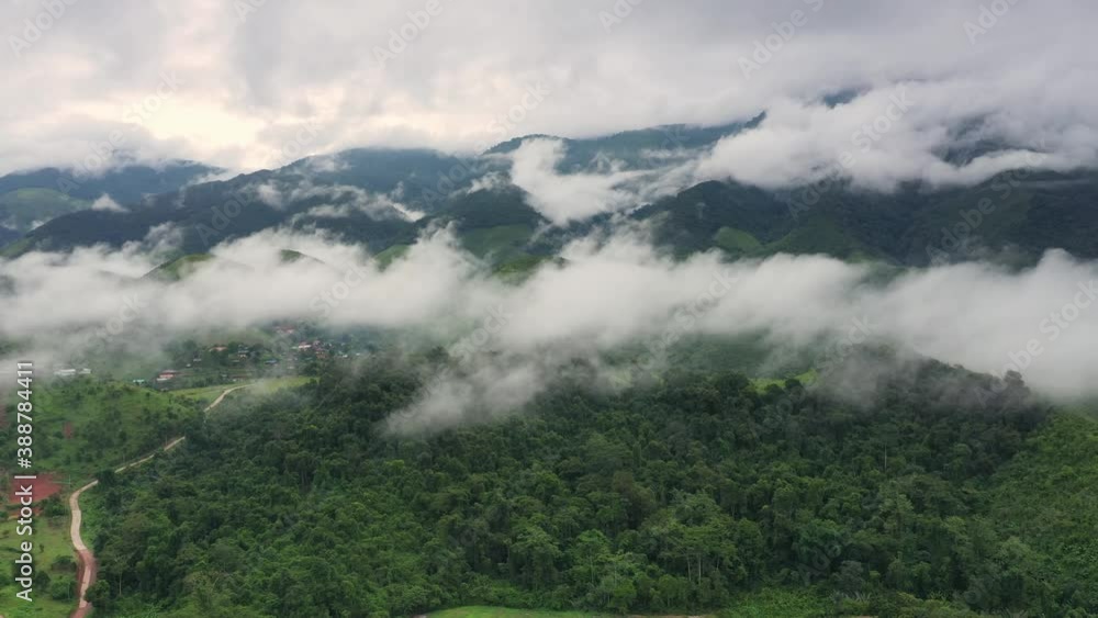 Aerial view over valley surrounded by mountains and covered with dense ground fog and mist High peaks wonderful morning sunrise natural Landscape. Sapan village, nan province, Thailand. Aerial view over valley surrounded by mountains and covered with dense ground fog and mist High peaks wonderful morning sunrise natural Landscape. Sapan village, nan province, Thailand.