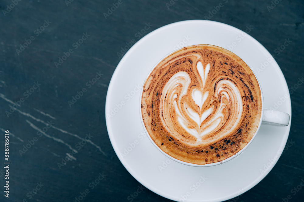 A Cup of hot latte art coffee on wooden table A Cup of hot latte art coffee on wooden table