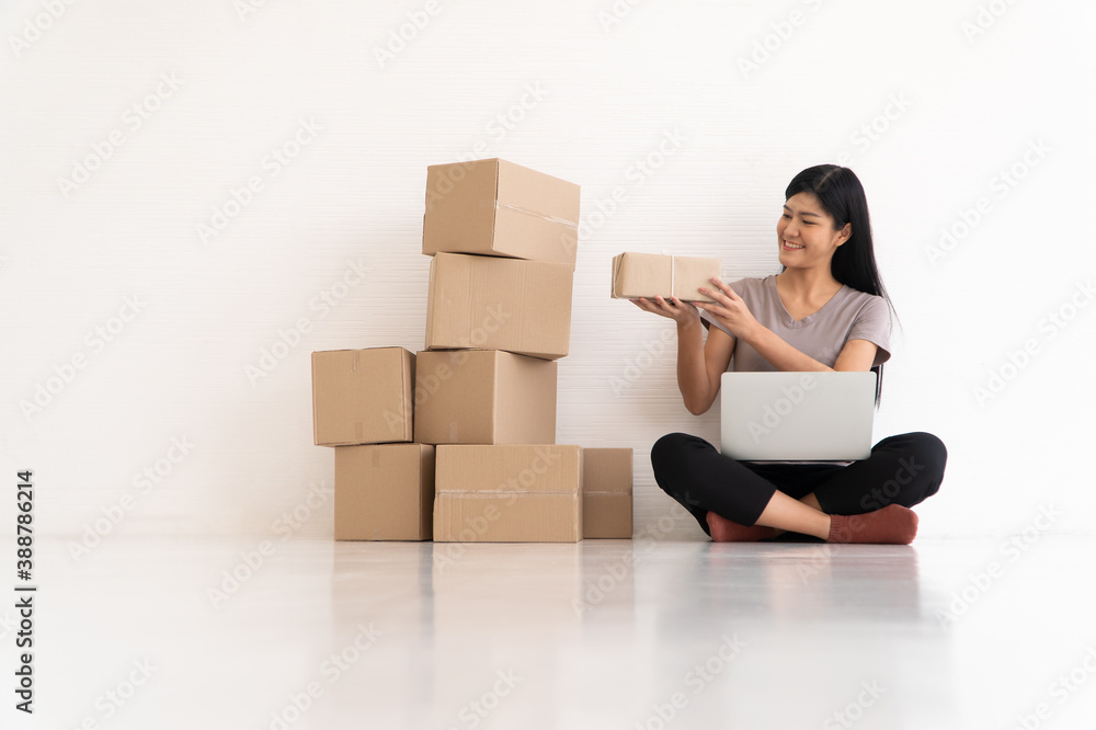 Happy Asian young entrepreneur, Smile for sales success after checking order from online shopping store at home office, Concept of merchant business online, eCommerce and delivery and lifestyle Happy Asian young entrepreneur, Smile for sales success after checking order from online shopping store at home office, Concept of merchant business online, eCommerce and delivery and lifestyle
