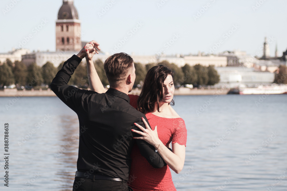 Young couple dancing together against the old city background. Travel and lifestyle concepts. Special tone effect Young couple dancing together against the old city background. Travel and lifestyle concepts. Special tone effect