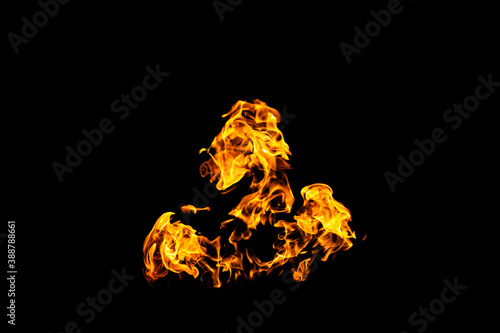 Fire flames on black background isolated. Burning gas or gasoline burns with fire and flames. Flaming burning sparks close-up  fire patterns. Infernal glow of fire in the dark with copy-space