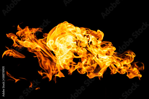 Fire flames on black background isolated. Burning gas or gasoline burns with fire and flames. Flaming burning sparks close-up, fire patterns. Infernal glow of fire in the dark with copy-space