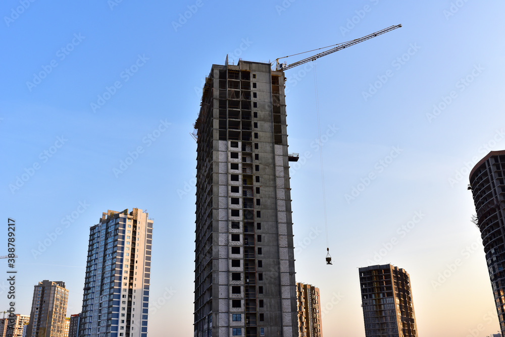 Tower crane in action at construction site. Construction of skeleton of new modern residential buildings. Preparing to pour of concrete into formwork. Erection multi-storey residential building