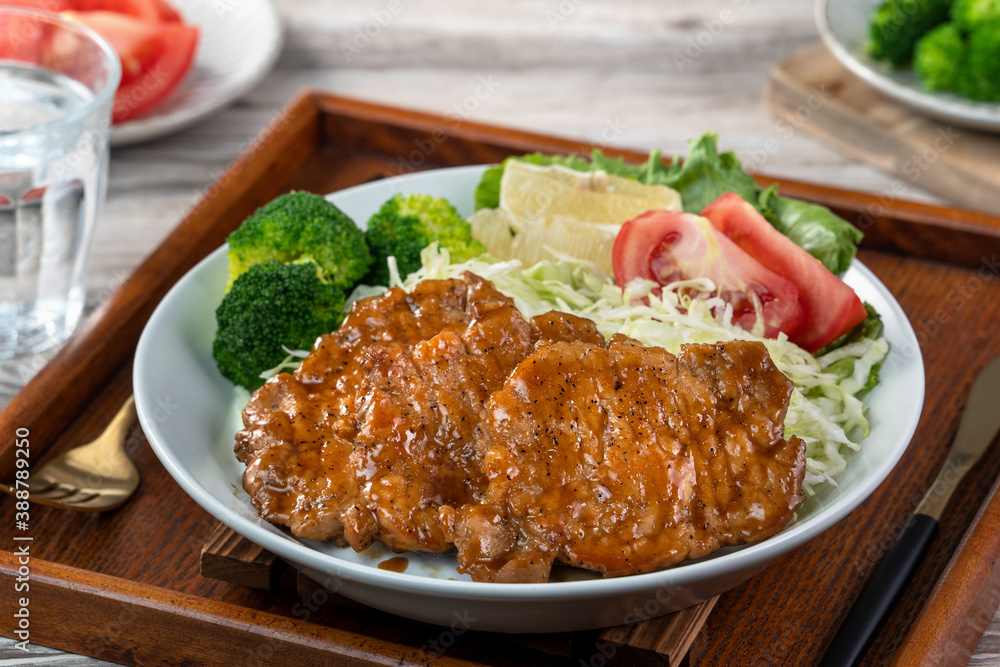 Delicious juicy pork chops with vegetable and fruit salad in a plate. Delicious juicy pork chops with vegetable and fruit salad in a plate.