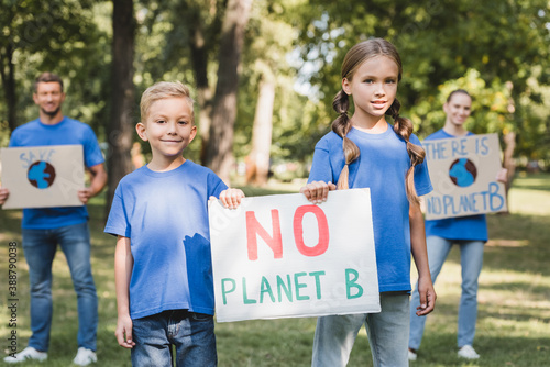 children holding placard with no planet b inscription near parents with posters on blurred background, ecology concept