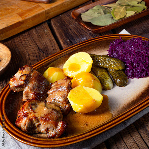 Rustic Snirtjebraten with red cabbage and cucumber photo