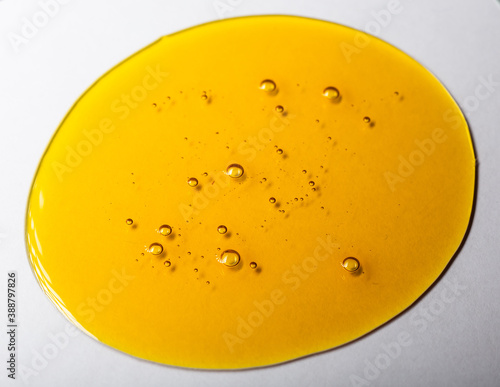 Yellow viscous liquid lecithin with bubbles on glass