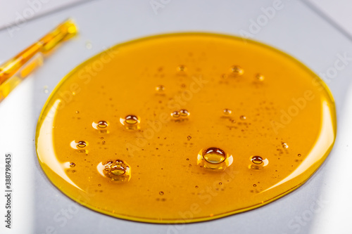 Fotografía Yellow viscous liquid lecithin with bubbles on glass