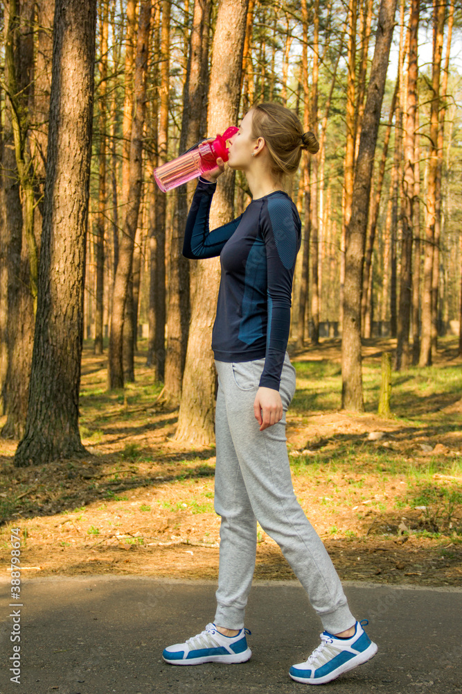 Sports girl crouches in the woods. The girl is warming up. Sports girl goes in for sports Sports girl crouches in the woods. The girl is warming up. Sports girl goes in for sports