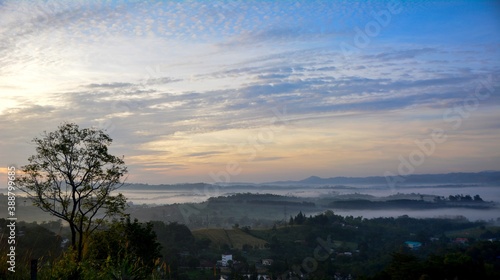 Beautiful Landscape of mountain layer in morning sun ray and winter fog