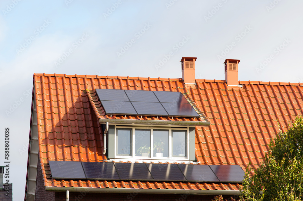 Solar panels on a red roof with dormer for electric power generation Solar panels on a red roof with dormer for electric power generation