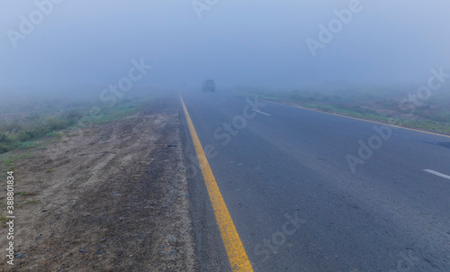 Asphalt road leaving in autumn fog