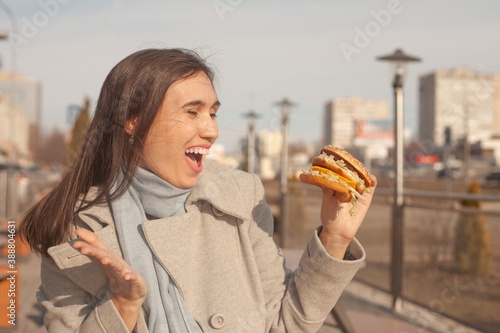 Beautiful girl is eating a cheeseburger