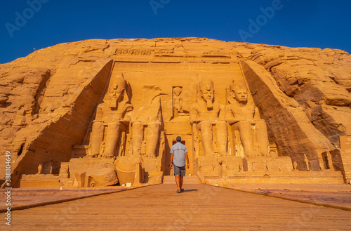 A young man walking towards the Abu Simbel Temple in southern Egypt in Nubia next to Lake Nasser. Temple of Pharaoh Ramses II  travel lifestyle