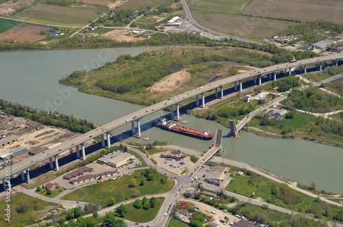 aerial view of the Welland Canal in St Catharines Ontario, ship passing under neath the Garden City highway bridge with the Homer drawbridge open