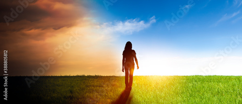 Frau in einer Landschaft mit von Dunkelheit ins Licht photo