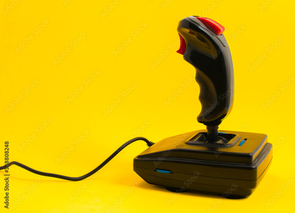 Old style gaming joystick from 80s, isolated on yellow color background. Copy space. Old style gaming joystick from 80s, isolated on yellow color background. Copy space.