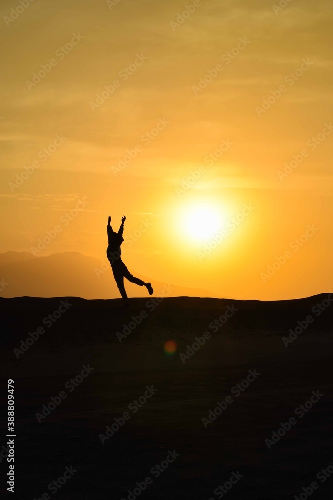 silhouette of a person running on the desert at sunset