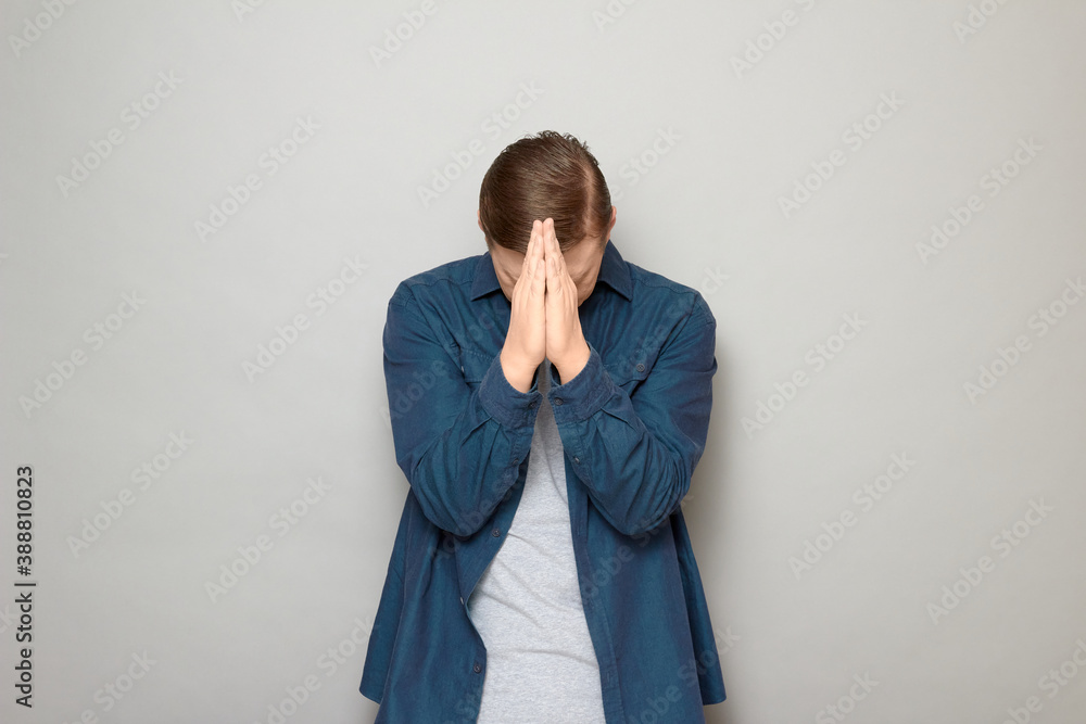 Man is holding hands in pray and bowing his head Man is holding hands in pray and bowing his head