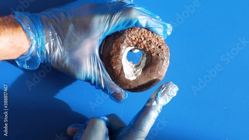 Doctor urologist in medical gloves doing prostate massage. Urology men's sex health concept. Male hand dipping finger into donut hole with cream lubrication. Prostatitis disease dysfunction problem 4K
