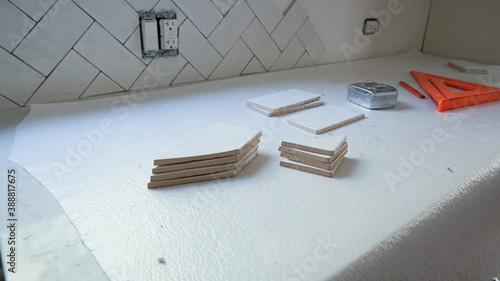 DIY home improvement project - installing white tile for a kitchen backsplash.