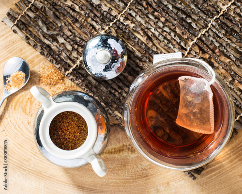 Glas of hot tea with sugar on wooden surface