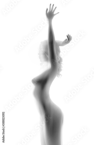 A blurry silhouette of a naked woman behind a transparent cloth. Blurred image with unrecognizable person.