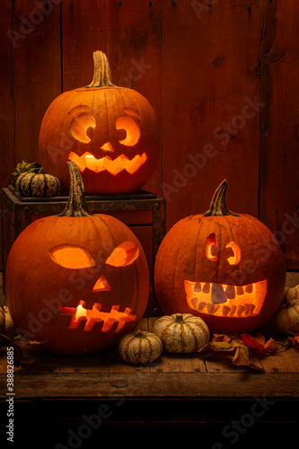 Fotografie silly and scary lit and carved pumpkins in side a barn for halloween