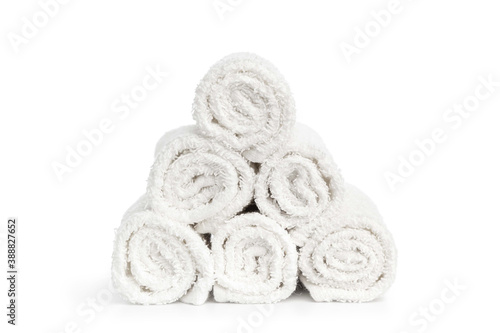 stack of white clean towels rolled up on white background