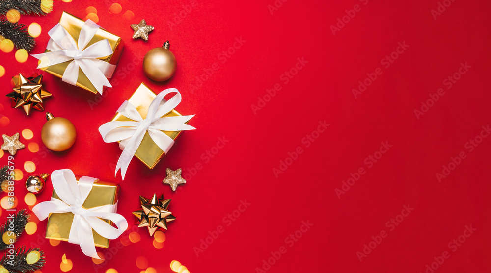 Christmas background greeting card with copyspace on right. Christmas gifts and golden decor on red background top view. Winter xmas holiday theme. Flat lay Christmas background greeting card with copyspace on right. Christmas gifts and golden decor on red background top view. Winter xmas holiday theme. Flat lay
