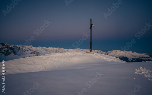 Panoramic view of gorgeous pink sunrise over glacier and high mountain peaks in the Alps. The cross on top of the mountain Nockspitze. Innsbruck and the Alps are seen from the Mount.  photo