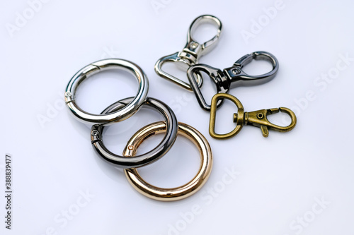 Chrome metal carabiners for a backpack strap. Round carabiner for a woman's bag. Stylish chrome fittings. Bag accessories metal clip buckle. Key ring with clipping path.