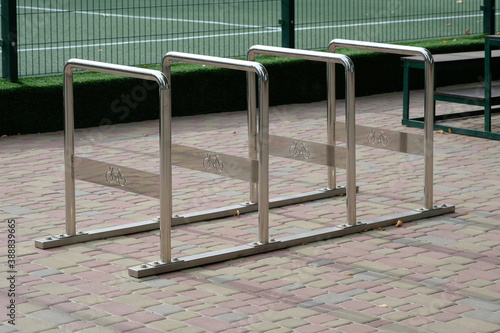 Empty Bicycle parking near the shop. Vertical bicycle parking on the sidewalk alley of the city. Bicycle stands near the park.