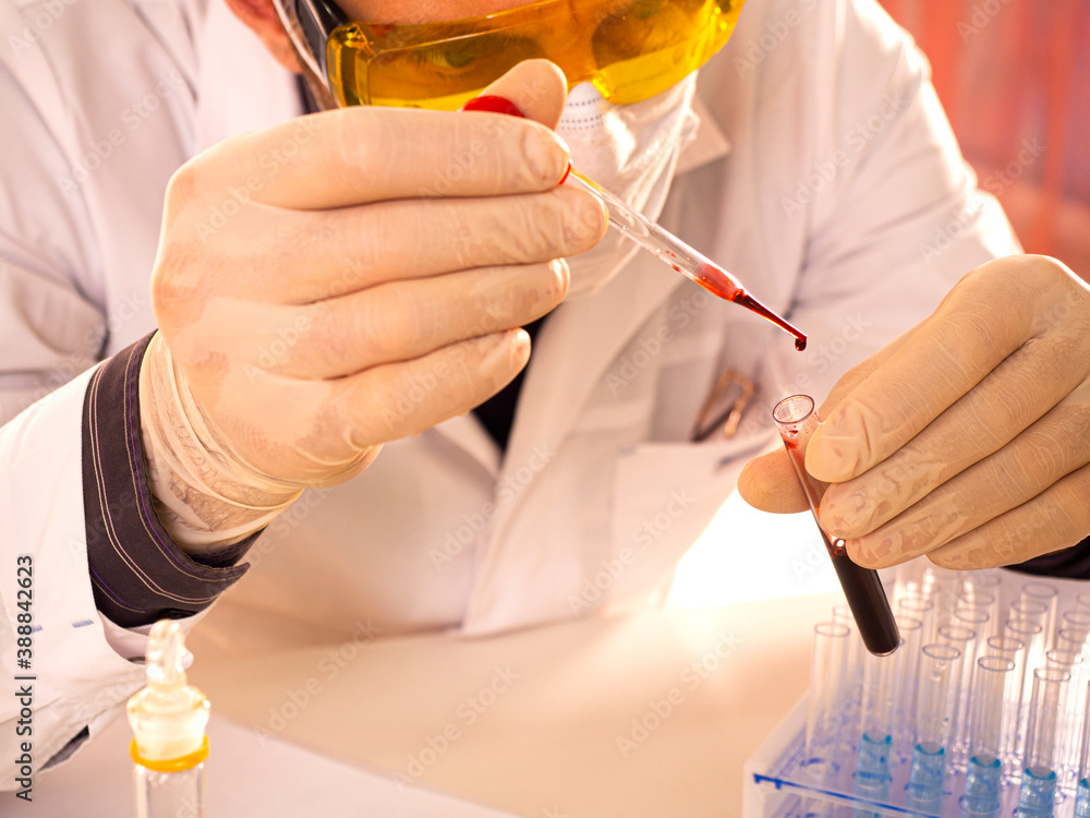 Modern lab. The researcher drops a blood sample into a test tube. Focus on a drop of blood. Modern lab. The researcher drops a blood sample into a test tube. Focus on a drop of blood.