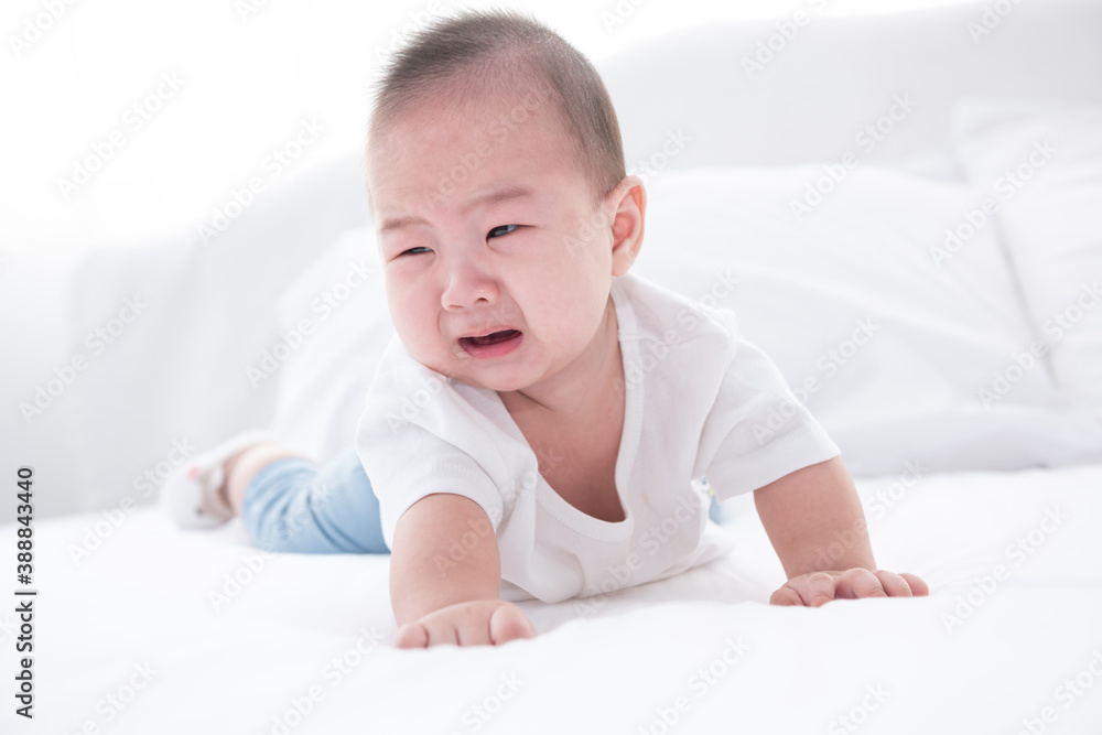 Asian infant crying baby. child tired and hungry on white bed. Children cry. Asia baby screaming. Healthy little kid shortly after birth. Asian infant crying baby. child tired and hungry on white bed. Children cry. Asia baby screaming. Healthy little kid shortly after birth.