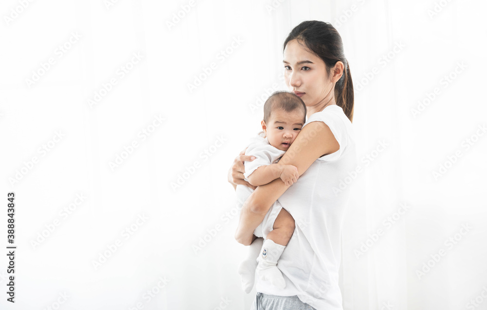 Pretty asian woman holding a newborn baby in her arms. Happy family. Laughing mother lifting her adorable infant baby son on white. Pretty asian woman holding a newborn baby in her arms. Happy family. Laughing mother lifting her adorable infant baby son on white.