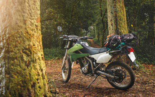 Adventure traveling enduro motocycle in mountain forest.