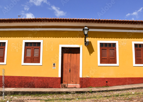 Facade of a beautiful yellow colonial building in the historic center of Alcântara, Maranhão, Brazil. The sky is blue. photo