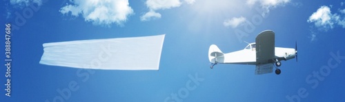 Flying airplane aircraft with string pulling and a white copy space banner