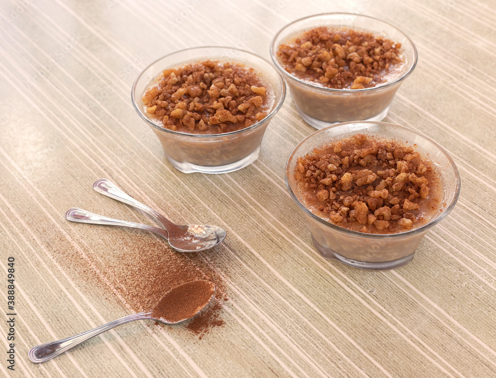 Three bowls with ashure, a typical Albanian dessert with wheat, dried fruit and cinnamon. Spoons. Three bowls with ashure, a typical Albanian dessert with wheat, dried fruit and cinnamon. Spoons.