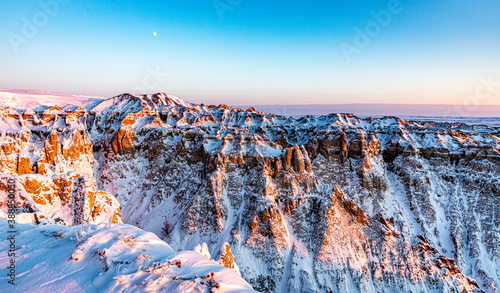 Snow covered ridges in Badlands National Park illuminated by the Golden Hour of Sunset