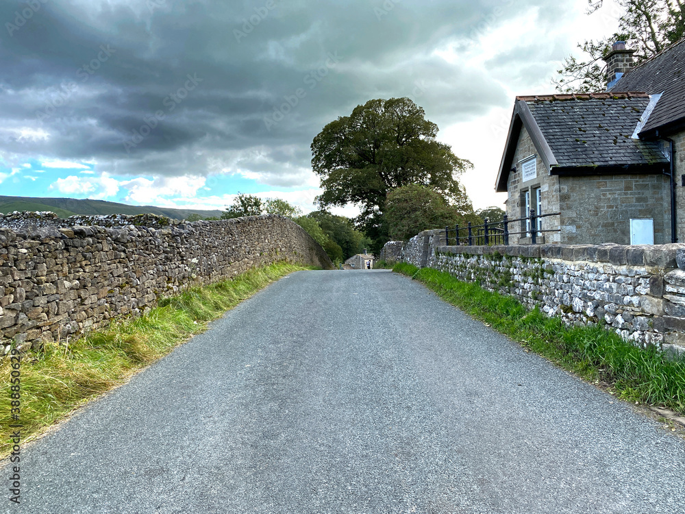 Looking along, Lauradale Lane, with dry stone walls, buildings and trees in, Linton, Skipton, UK Looking along, Lauradale Lane, with dry stone walls, buildings and trees in, Linton, Skipton, UK