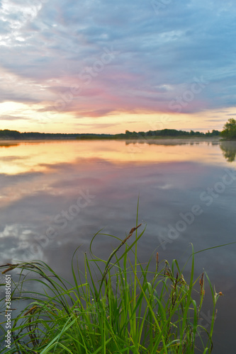 colorful and misty dawn over a small river