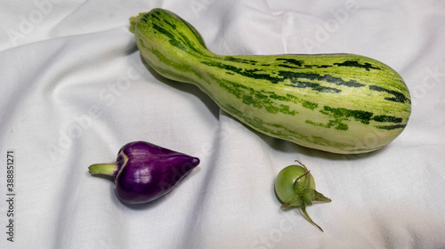photo of pepper and green tomato. vegetables are on the fabric. vegetarian still life. healthy food. autumn harvest